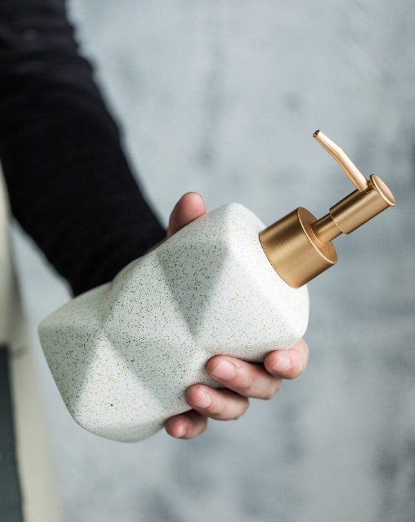 white luxurious bathroom dispenser with gold details